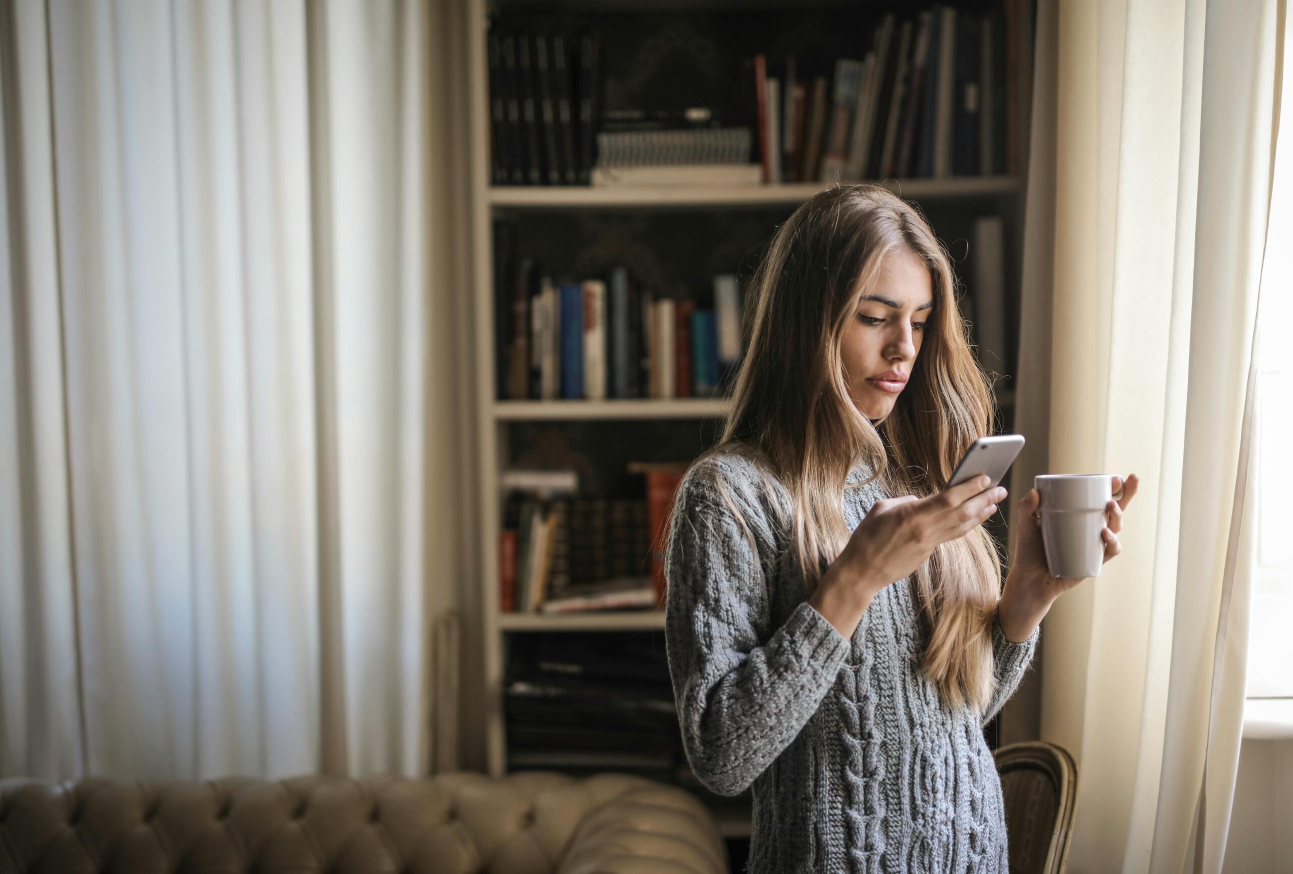 Woman inside on her phone. Picture by olly on pexels